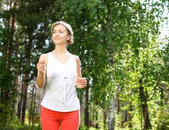 Young girl in a white shirt and red pants likes to run outdoors.