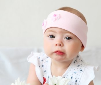 portrait of an infant baby girl wearing a hat