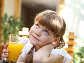 portrait of little girl with orange juice outdoors