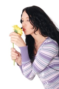 young charming brunette in a sweater and jeans with a yellow flower in the hands