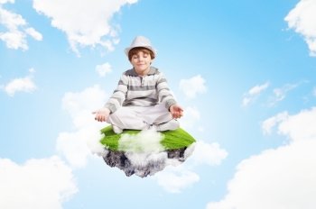 Little cute boy relaxing. Image of little boy sitting on cloud and meditating