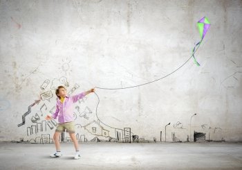 Boy with kite. Little boy playing with kite against wall background. Childhood concept