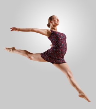 Girl dancing in a color dress with a gray background. isolate