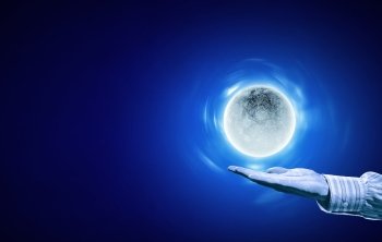Moon on hand. Person hand with moon on palm on blue background
