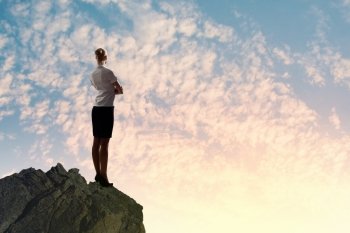 Businesswoman on top of hill. Image of businesswoman standing on top of hill