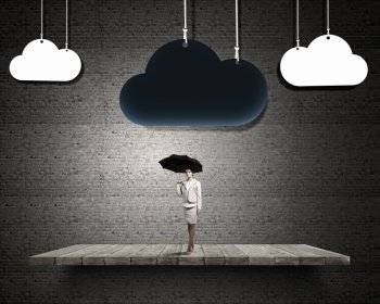 Woman with umbrella. Young businesswoman with black umbrella standing under black cloud