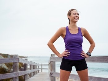 Sporty young woman standing on the sea coast