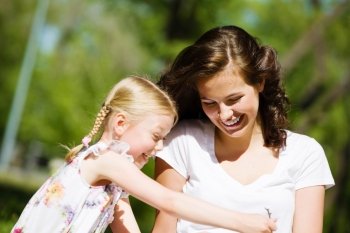 Kid with mom. Image of cute girl and her mother playing in park