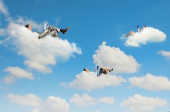 Business people lying on clouds. Image of businesspeople lying on clouds with tablet pc