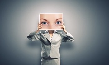 Woman showing photo. Unrecognizable businesswoman holding big photo with eyes
