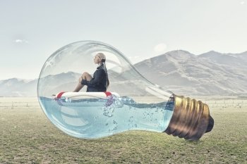 Woman inside light bulb. Young businesswoman floating on life buoy inside of light bulb