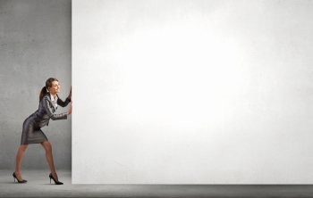 Woman pushing banner. Attractive businesswoman pushing white blank wall. Place for text