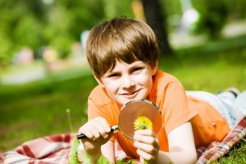 Boy in park. Image of cute boy playing in park with magnifier