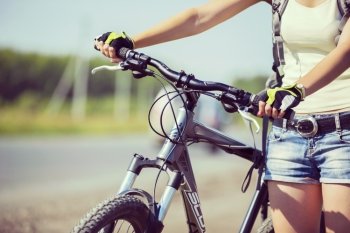 Close up of young beautiful woman riding a bicycle in a park