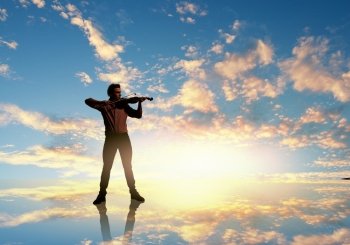Man violinist. Silhouette of man playing violin at sunset