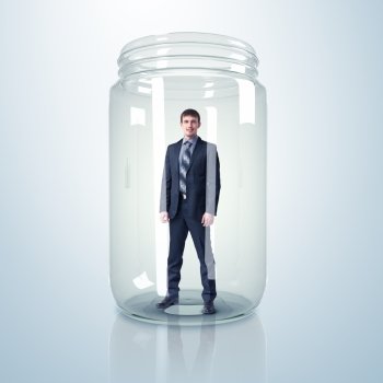 Businessman trapped inside a transparent glass jar. Businessman inside glass jar