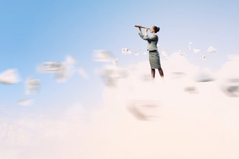 Business woman with telescope. Image of businesswoman looking in telescope standing against clouds background