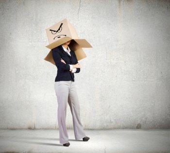 Hiding emotions. Businesswoman in suit wearing carton box on head