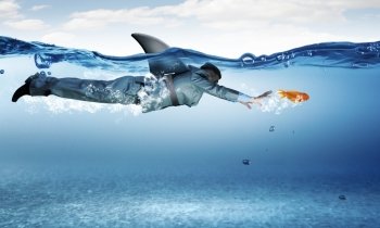 Shark of business world. Young businessman with shark flipper swiming under water