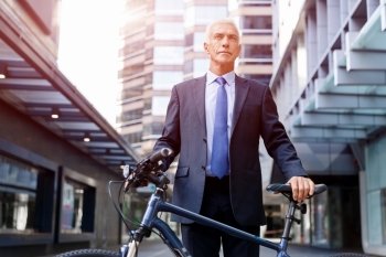 Successful businessman riding bicycle. Successful businessman in suit riding bicycle 