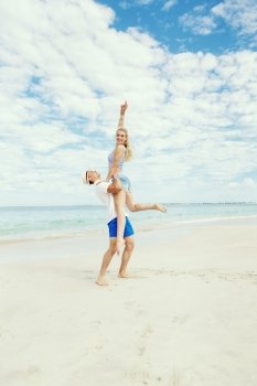 Happy couple  jumping on beach vacations. Travel concept of young couple cheering for summer holidays on beach