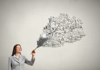 Create your business. Young attractive businesswoman with paint brush and business sketches on wall