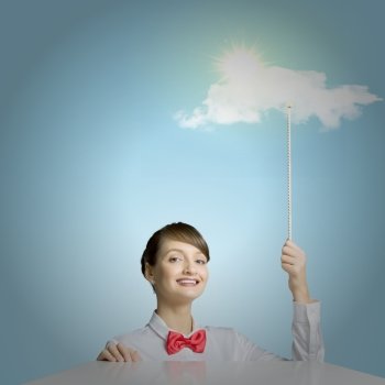 Success concept. Young woman holding balloon with sun shining above