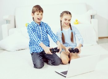 Kids playing game console. Cute kids sitting on floor playing games on joystick