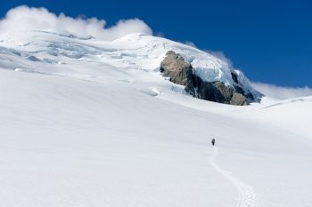 New Zealand. Man walking among snows of New Zealand mountains