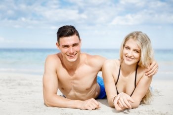 Romantic young couple on the beach. Romantic young coupleon the beach looking at camera
