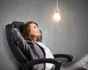 Lady boss. Young confident businesswoman sitting in chair with legs up