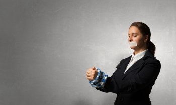 Release of guiltless accused. Young businesswoman with tape on mouth and tired hands