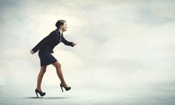 Woman at start. Side view of businesswoman in suit ready to run