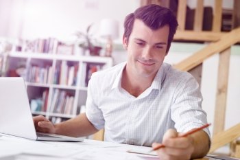 Male architect in office. Male architect with computer studying plans in office