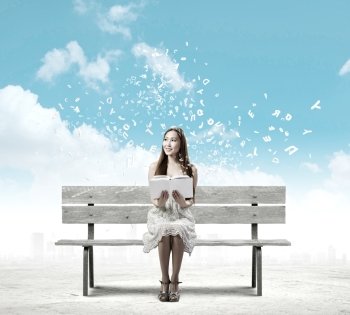 Girl reading book. Asian pretty woman sitting on bench and reading book
