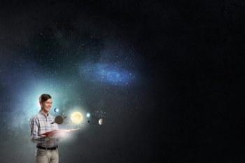 Guy with book in hands. Young man with opened book and planets of space spinning around
