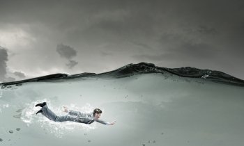 Businessman under water. Young businessman in suit swimming in stormy waters