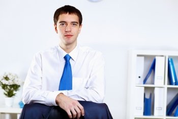 Young smiling happy businessman at work in office