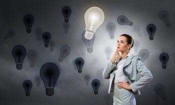 Young pretty businesswoman with light bulb over head. Thoughtful businesswoman