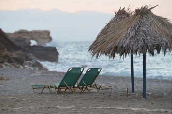 Beach chairs with straw umbrellas on sea beach