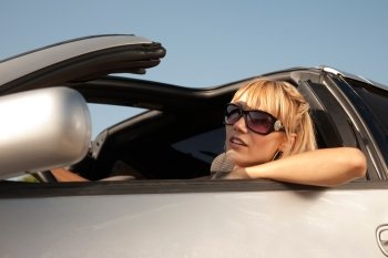 Girl in big sunglasses  sits in the car 