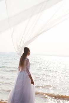 Bride on the beach with flying veil
