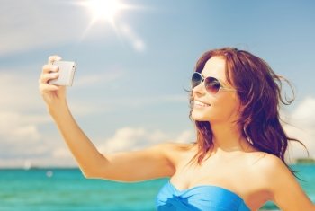 close up of beautiful woman on the beach with phone. woman in bikini with phone