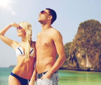 people, summer holidays, travel and vacation concept - happy couple over exotic tropical beach background