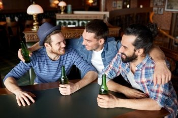 people, leisure, friendship and bachelor party concept - happy male friends drinking bottled beer and hugging at bar or pub