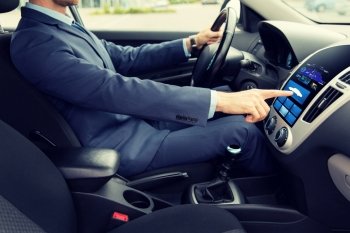 transport, modern technology and people concept - close up of young man in suit driving car and pointing finger to car icon on board computer screen