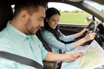 leisure, road trip, travel and people concept - happy man and woman driving in car and searching location on map