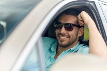 road trip, transport, travel and people concept - happy smiling man in sunglasses driving car
