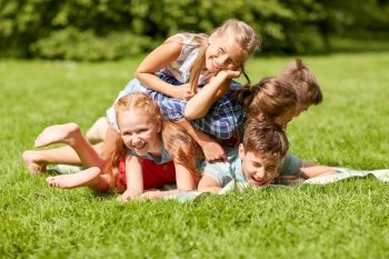 friendship, childhood, leisure and people concept - group of happy kids or friends playing and having fun in summer park