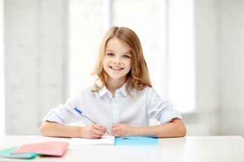 education, elementary school, learning and people concept - happy smiling girl with notebook and pen